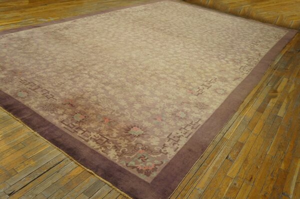 Muted lavender and beige traditional rug with a wide dark border, placed on distressed wood planks.