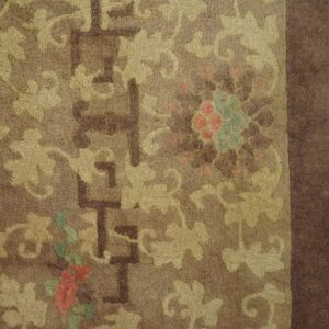 Textured brown rug features tan floral scrolls, geometric accents, and subtle red and teal highlights.