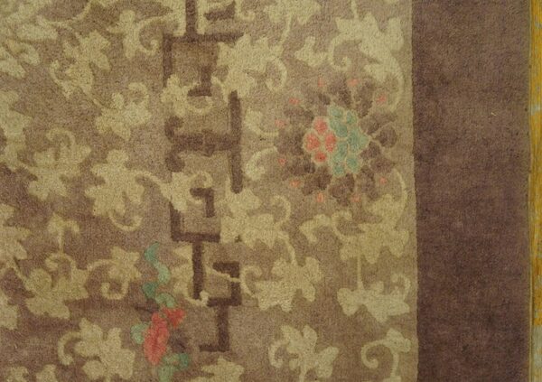 Textured brown rug features tan floral scrolls, geometric accents, and subtle red and teal highlights.