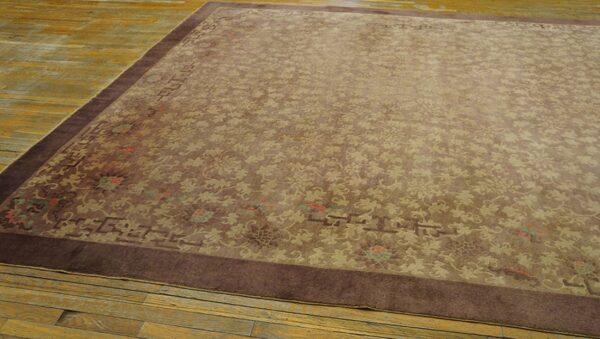 Brown rug with subtle floral and vine patterns and a dark border on rustic yellow wood floors.