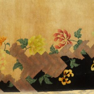 Plush gold rug with colorful stylized floral motifs rising from a jagged black and brown base.