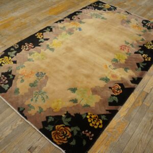 Rectangular rug with a light gold center and multicolor floral motifs along a black and brown stepped border.