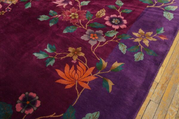 Deep purple and magenta rug with large orange, pink, and teal floral vine motifs on wood flooring.