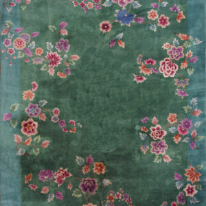 Deep jade green rug featuring winding vines of pink, purple, and coral flowers with a solid teal border.