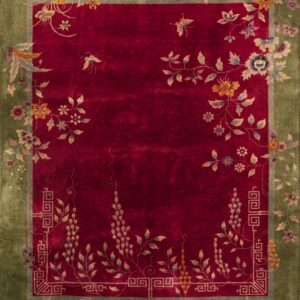 Velvety deep crimson rug with an olive green border and scrolling stylized floral and butterfly patterns.