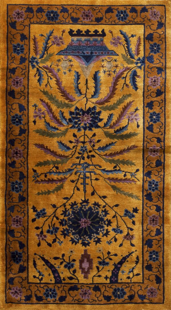 Mustard yellow rug with a central vase design and dense stylized foliage in blue, purple, and green.