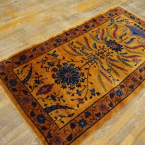 A high-pile gold rug with dark blue and rust traditional patterns rests on distressed wooden floorboards.
