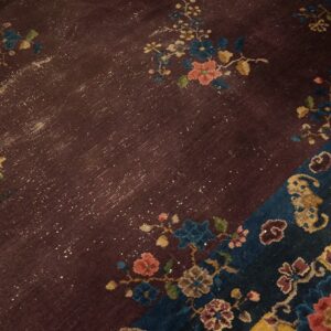 Deep purple rug detail showing distressed floral pattern and sections of dark blue and bright yellow.