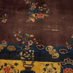 Maroon, blue, and gold rug detail showing complex floral sprays, cloud shapes, and border patterns.