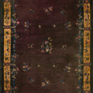 Dark plum plush rug with scattered floral sprays and an intricate border of gold, blue, and black.
