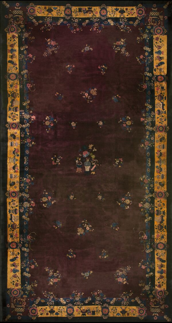 Dark plum plush rug with scattered floral sprays and an intricate border of gold, blue, and black.
