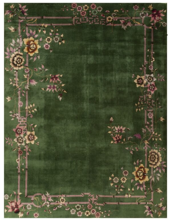 A deep green rug with an ornamental mauve border depicting bamboo and multi-colored floral sprays.