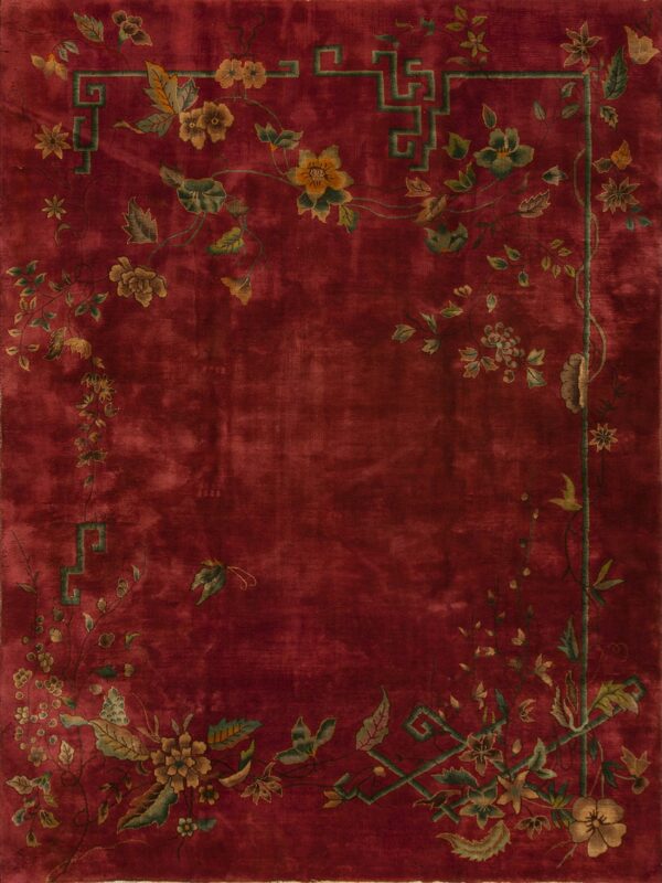 Deep red rug featuring trailing vines, gold flowers, and a green key pattern border.