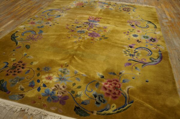 Lustrous golden yellow rug with dense floral patterns in pink, blue, and purple colors on a wooden floor.