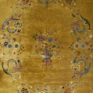 Gold rug with a plush texture and detailed floral medallion framed by an oval scrolling border.