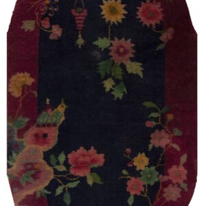 High-pile oval rug with a navy center, burgundy border, and detailed pink, green, and yellow floral pattern.