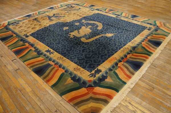 Blue and tan dragon rug featuring a rainbow wave border sits on distressed yellow wood floors.