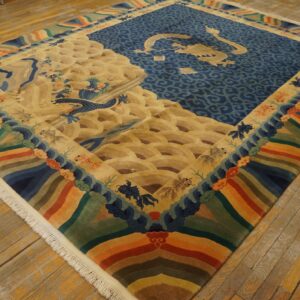 Blue, gold, and multicolored rug with a large central dragon pattern rests on distressed wood flooring.