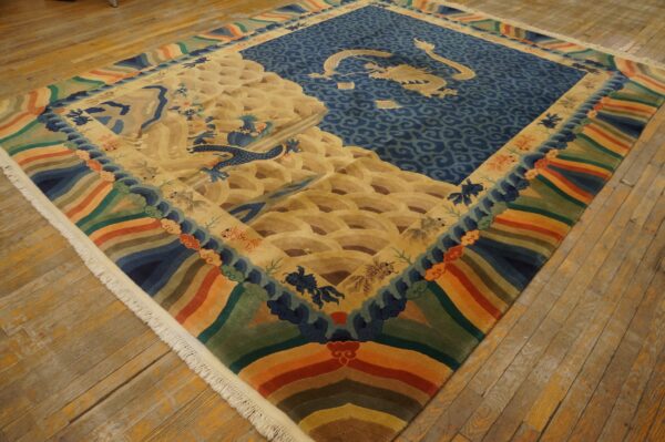 Blue, gold, and multicolored rug with a large central dragon pattern rests on distressed wood flooring.