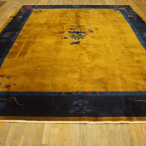 High pile mustard yellow rug featuring navy borders with scattered blue and maroon floral details on a wood floor.