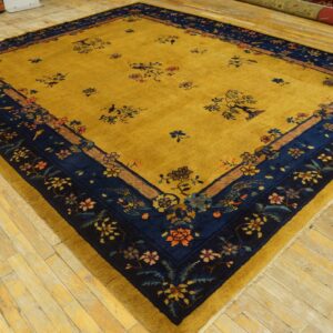 Mustard yellow rug with navy floral borders and scattered motifs, displayed on light wood floors.