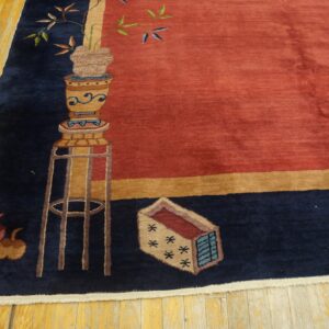 Rust field and navy border rug featuring a potted plant pattern resting on yellow hardwood planks.