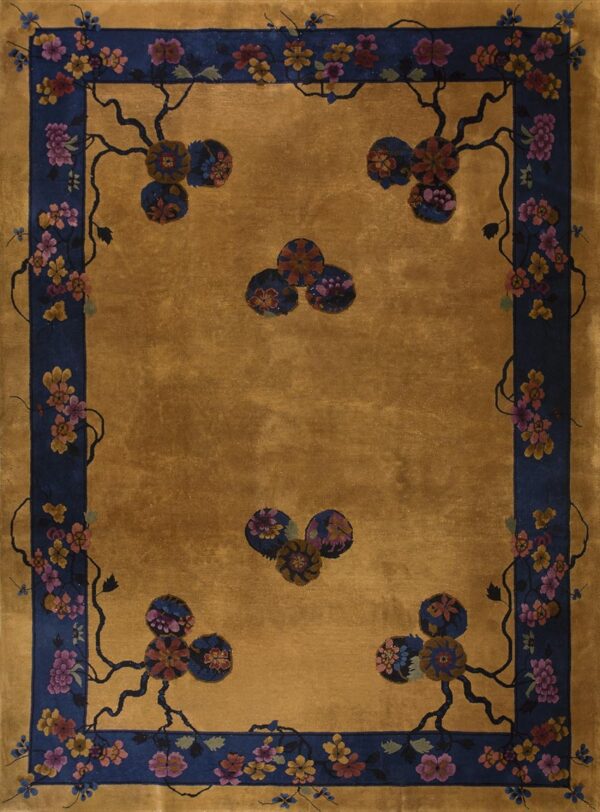 A golden rug with a navy blue border featuring trailing pink and yellow floral vines.