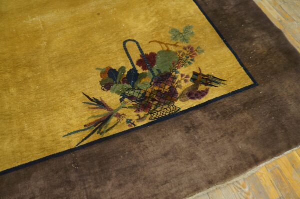 Gold field rug with a central fruit basket pattern framed by a solid dark brown outer border.