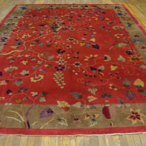High-pile red rug features an elaborate multi-colored floral pattern with a wide brown border on wood planks.
