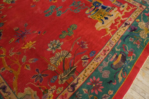 Highly detailed red rug with multicolored floral designs and a contrasting teal and beige decorative border.