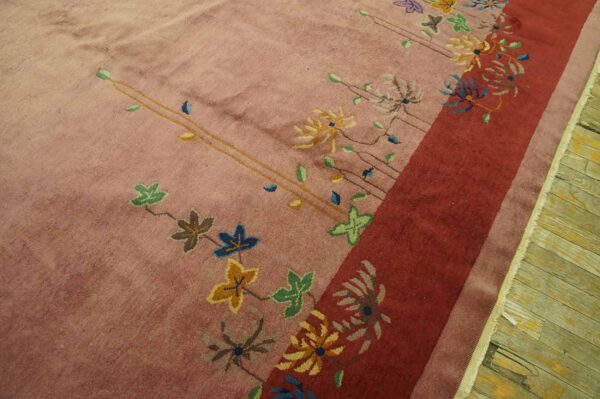 High pile blush rug featuring scattered stylized flowers and a prominent, solid red vertical border.