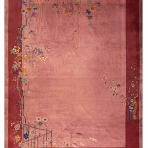 Dusty pink rug with a deep cranberry border and stylized multi-color floral and vine motifs.