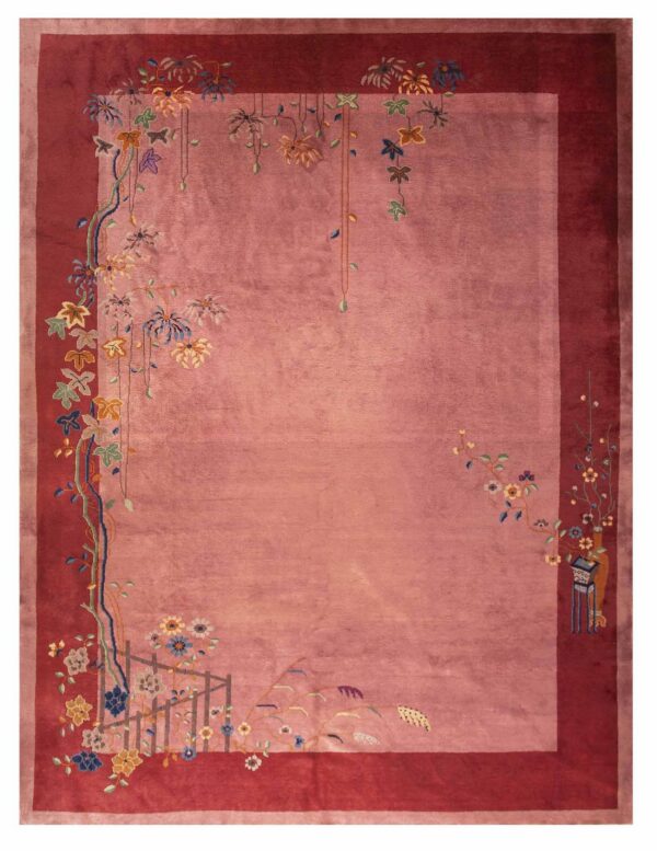 Dusty pink rug with a deep cranberry border and stylized multi-color floral and vine motifs.