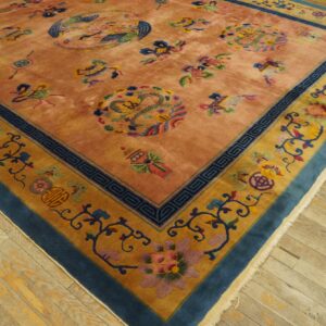 High-pile salmon rug with colorful mythological motifs and a wide blue and gold floral border on wood.