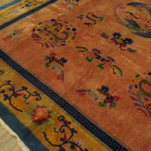 Terracotta rug with colorful dragon, bird, and floral motifs has wide mustard and blue borders.