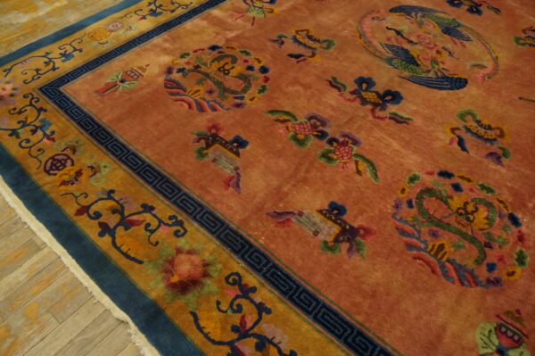 Terracotta rug with colorful dragon, bird, and floral motifs has wide mustard and blue borders.