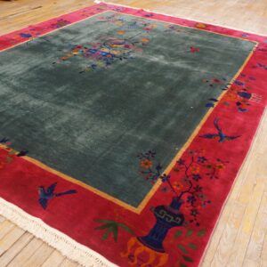 High-pile teal rug with colorful birds and flowers features a bold magenta border on wood planks.