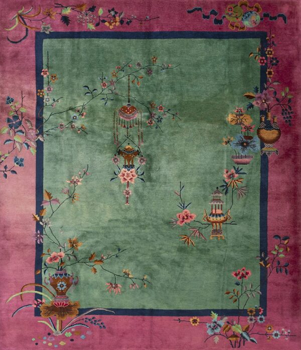 Green field rug with a magenta border featuring detailed florals, vases, and decorative lanterns.