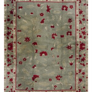 Dusty teal rug with a red and pale green all-over floral pattern and banded outer border.