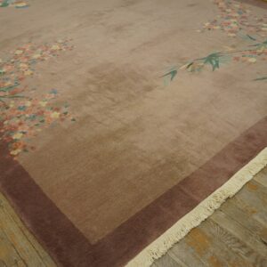 Mauve rug featuring a scattered floral and bamboo pattern with a dark border on distressed wood flooring.