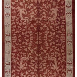 Terracotta rug with a dense beige foliate pattern, four stylized birds, and an elaborate decorative border.