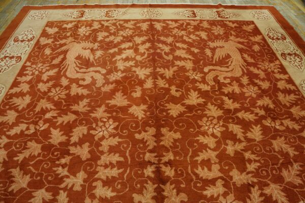 Low-pile rust rug with tan foliage and two opposing bird figures, framed by a decorative cream border.