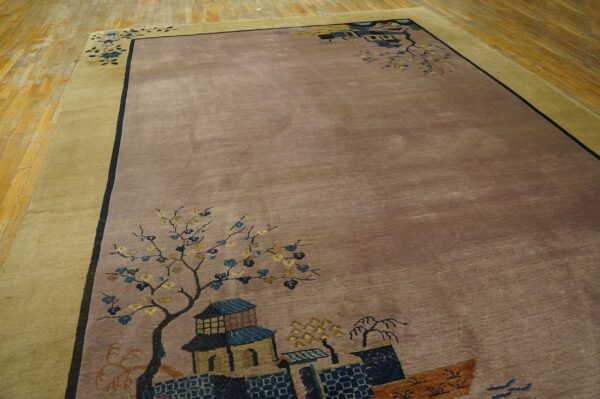 Muted taupe and gold bordered rug with scenic corner motifs of flowering trees and stylized buildings on hardwood floor.
