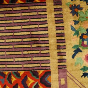 Colorful rug featuring gold, purple, and blue geometric borders transitioning to a vibrant floral pattern.