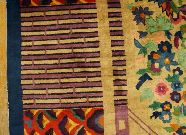 Colorful rug featuring gold, purple, and blue geometric borders transitioning to a vibrant floral pattern.
