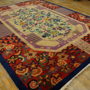 Multi-colored floral rug featuring a beige center field and bold red and geometric purple borders on wood flooring.