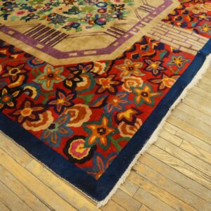 Multicolor stylized floral rug with red and beige fields and geometric borders on light wood flooring.