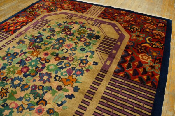 A vibrant rug with a tan floral center and red outer border featuring purple geometric accents on wood flooring.