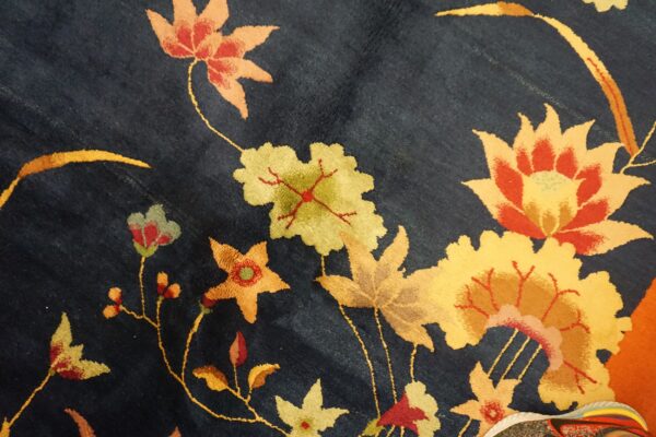 Dark blue plush rug with yellow, orange, and red floral patterns; the toe of a sneaker is visible.