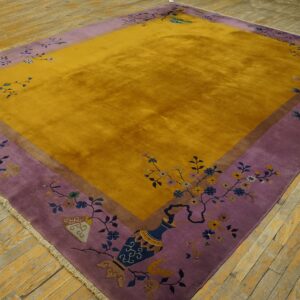 Shaggy gold rug featuring an ornate purple border with detailed floral and decorative vase motifs on wood flooring.